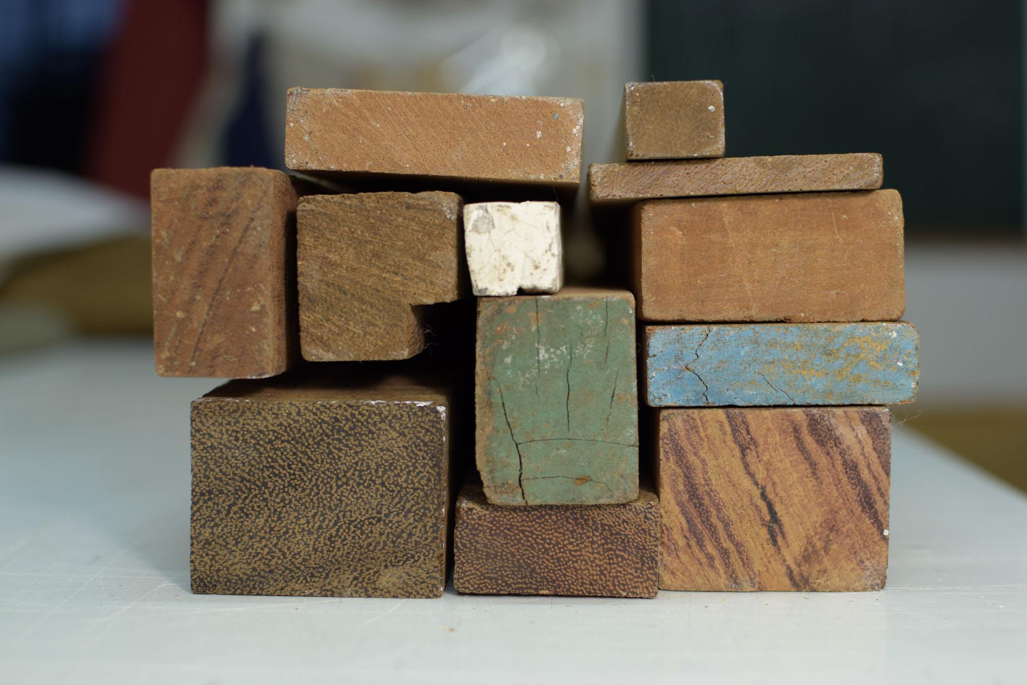 Holzleisten aus einer Bootsbauer-Werkstatt aus besonders festem dunkelbraunen Holz zu einem Puzzle zusammen gelegt.