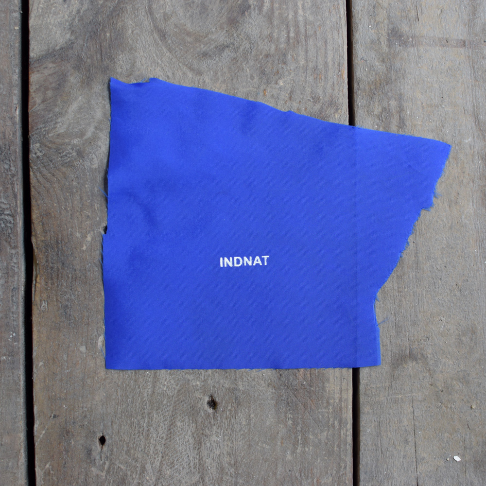 INDNAT Logo auf blauem Stoff.
